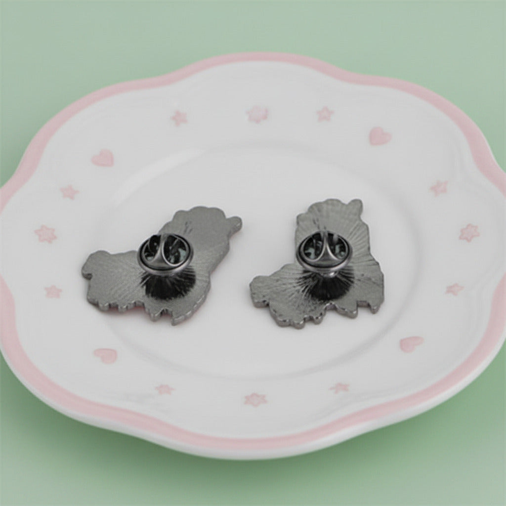 Two enamel pins of cartoon llamas, one pink and one blue, on a white background.
