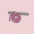 Crochet hook with pink yarn on a  pink and white background
