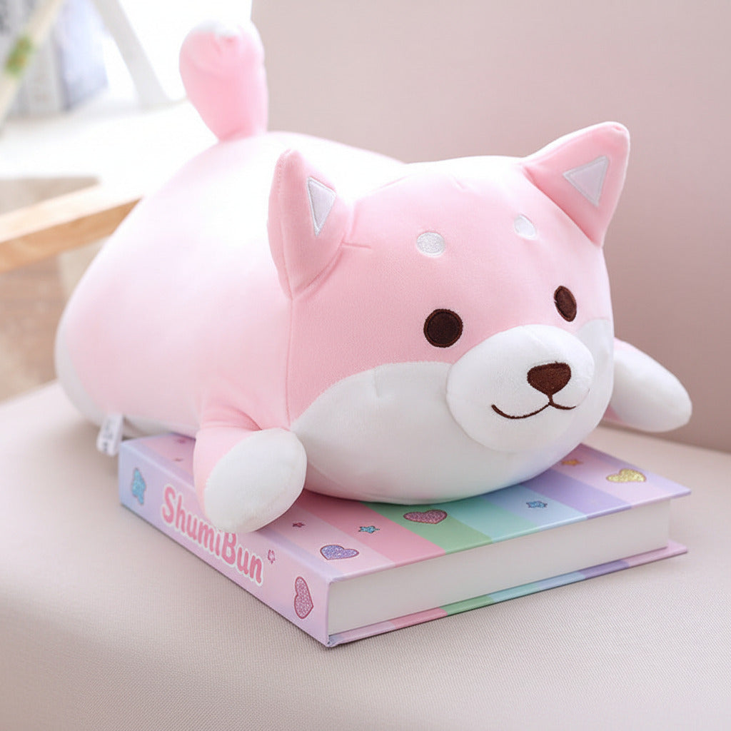 Cute pink and white plush toy resembling a fox on a book with a blurred background