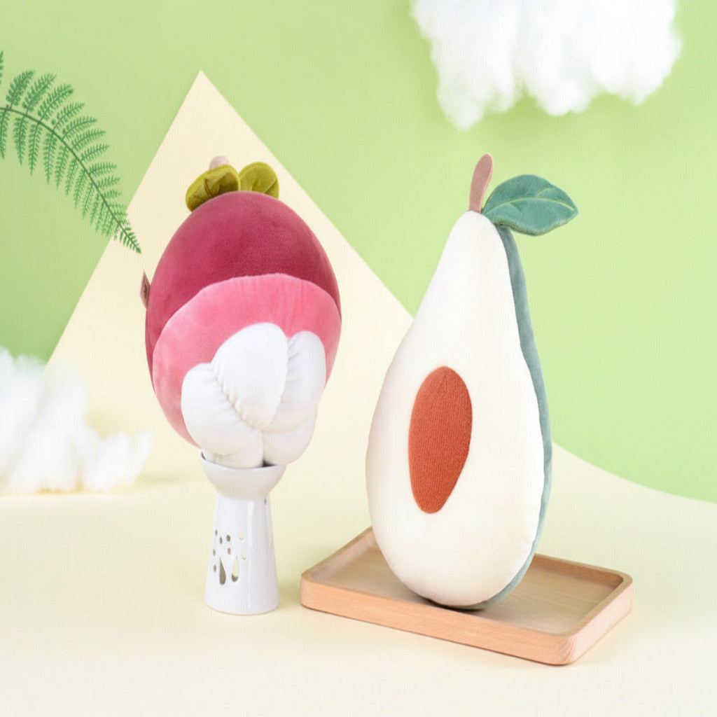Plush toys shaped like a mangosteen and an avocado on a light green background