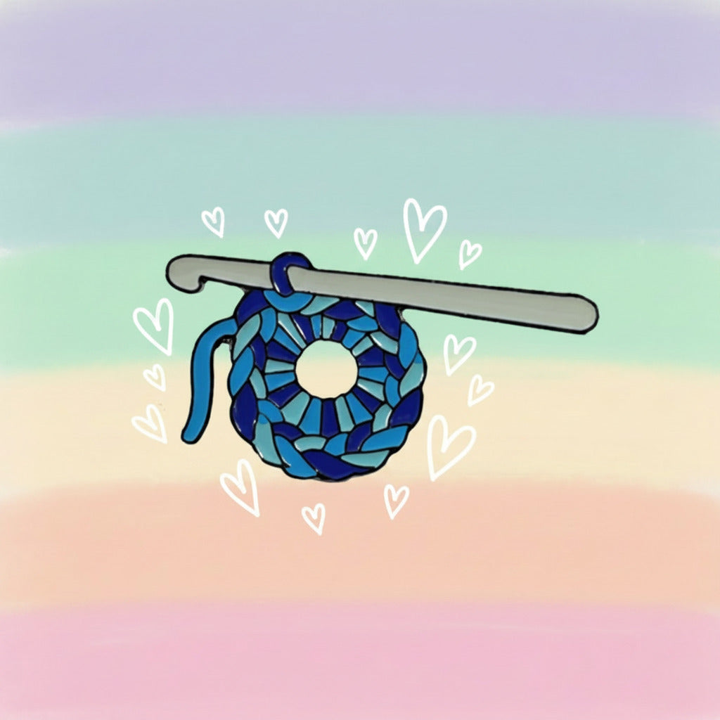 Crochet hook with blue yarn on a white and pastel rainbow background