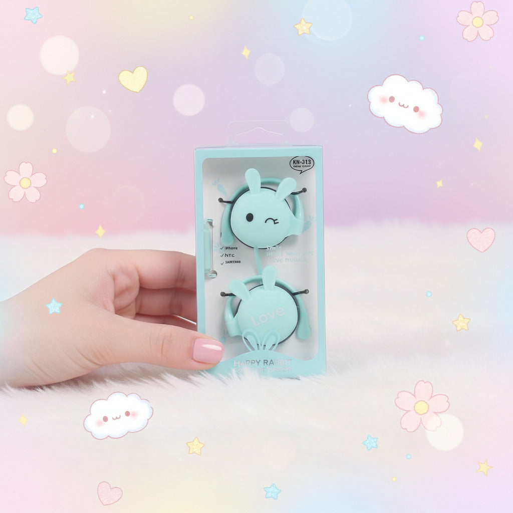 Blue cartoon bunny character toy in packaging on a white surface with decorative items in the background