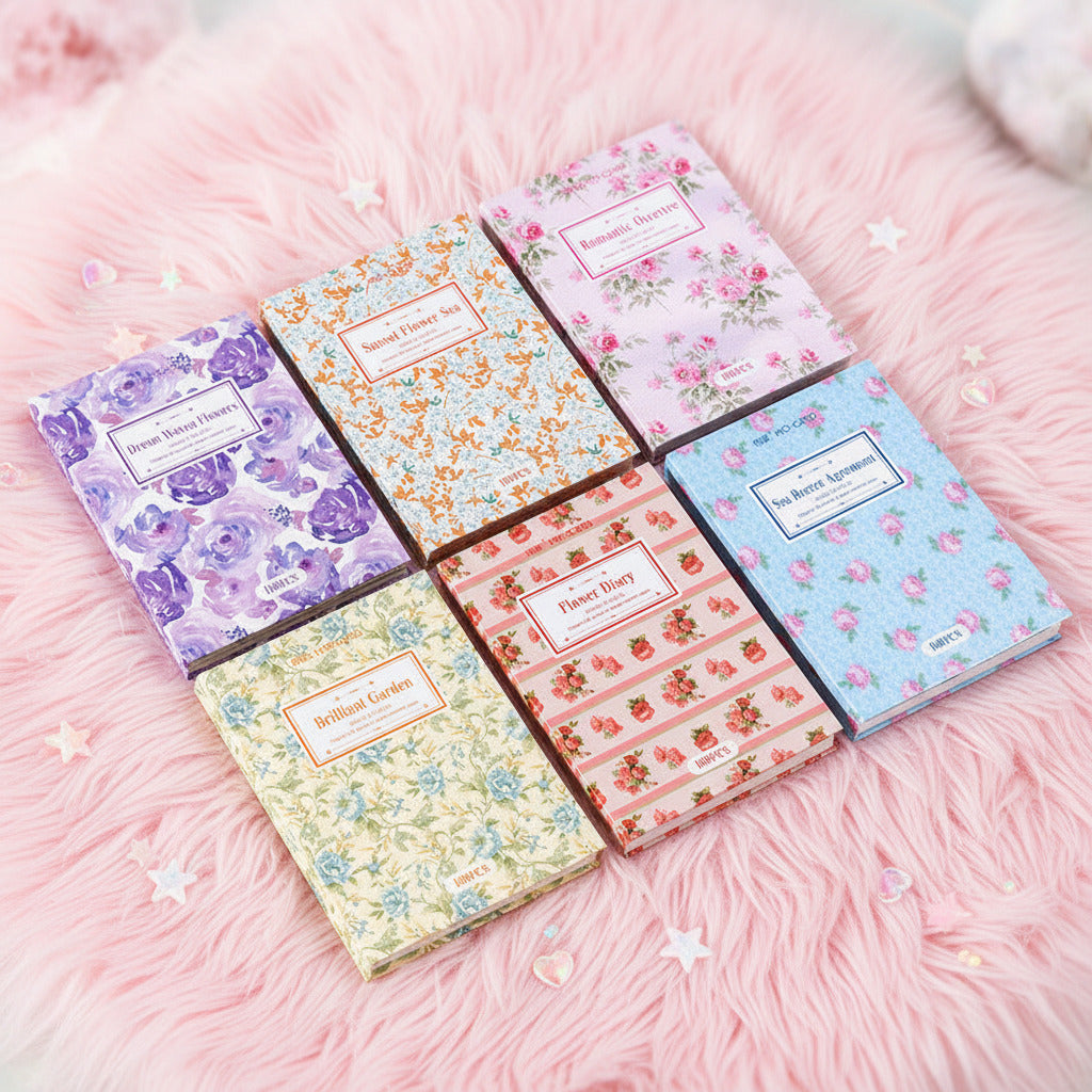 Set of six floral patterned notebooks on a pastel fuzzy background