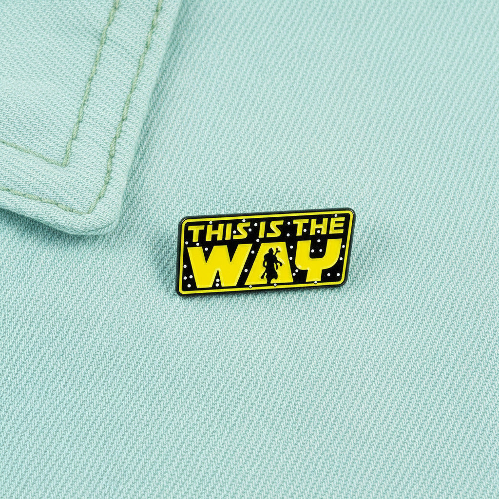 Enamel pin with 'This is the Way' text on pastel cyab colored denim fabric