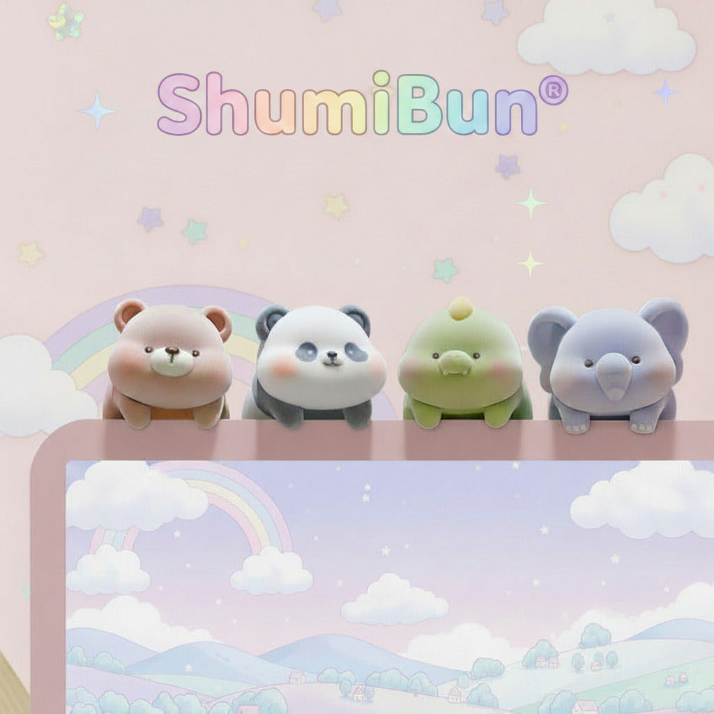 Four cute cartoon animal desk accessories sitting on top of a pastel desk mat with a rainbow and cloud illustration. The set includes a pink bear, a black-and-white panda, a green dinosaur, and a blue elephant, all in a soft pastel color palette against a matching pink wall background.