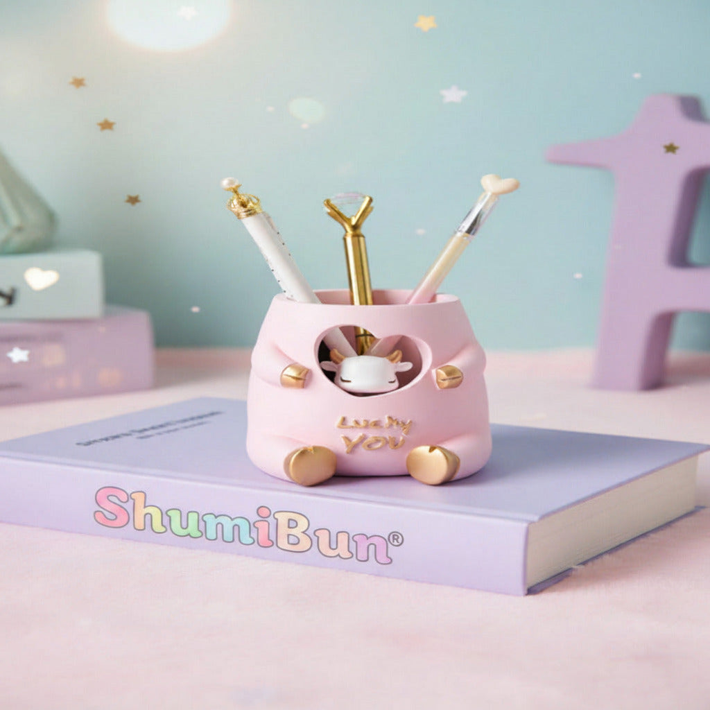 Pink animal-shaped pen holder with stationery items on a light blue surface