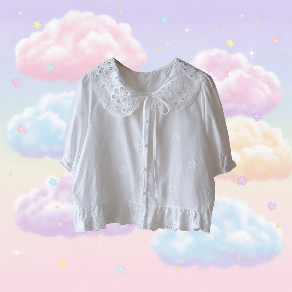 White blouse with lace details on a white background with pastel rainbows and clouds