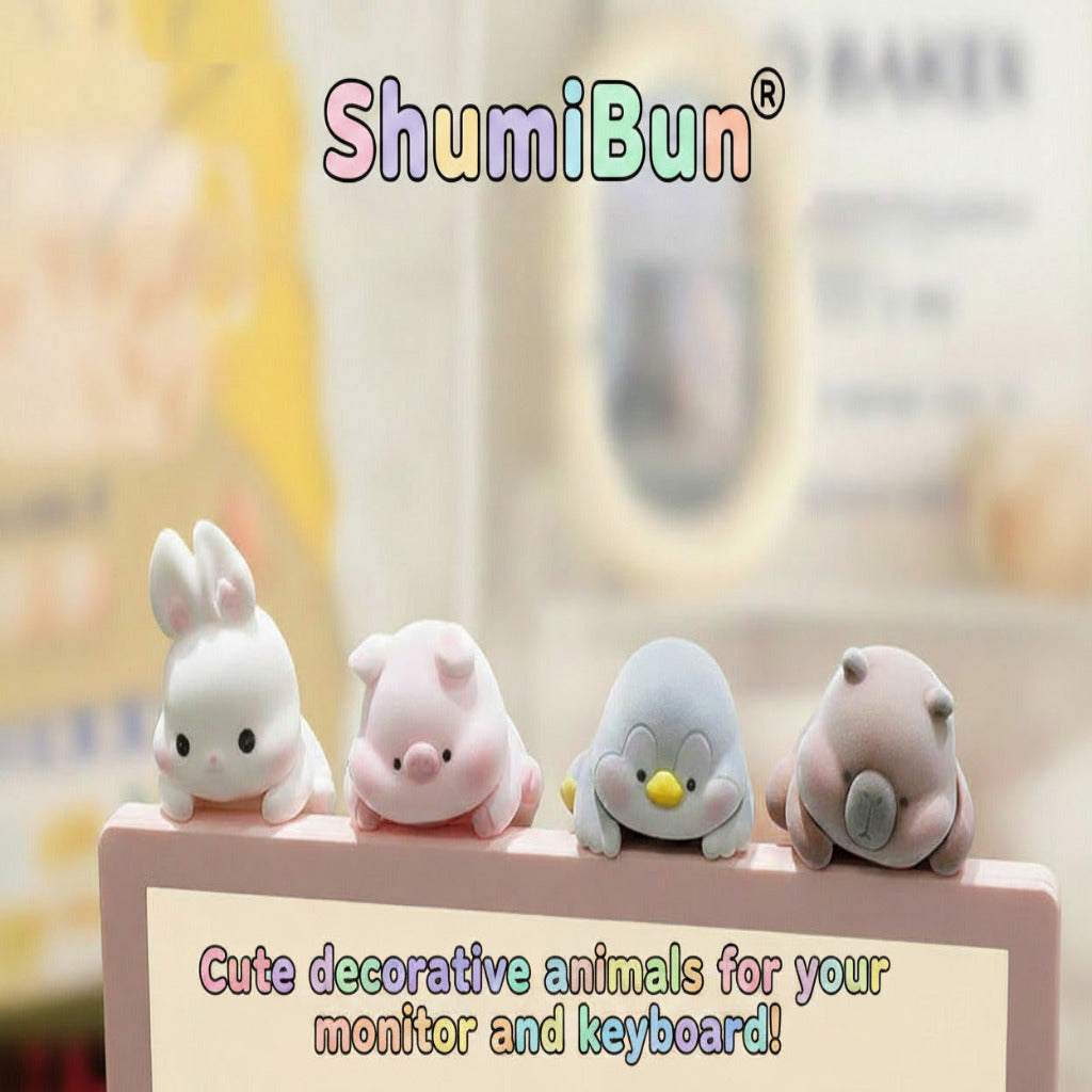 Four cute animal-shaped monitor and keyboard decorations lined up on a pink display stand. The set includes a white bunny, a pink pig, a light blue penguin with a yellow beak, and a brown bear with a gray snout.