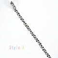 A white elastic band with a black cow print pattern, shown diagonally on a white background with the text 'Style A' in the bottom-left corner.