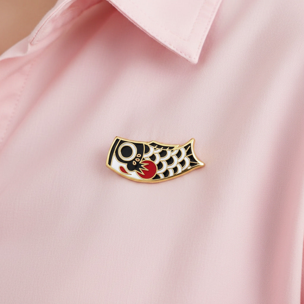 Decorative fish-shaped object with black, white, and red design on a white background