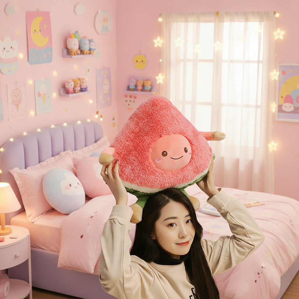 Person holding a plush watermelon toy against a dark wall with framed pictures.