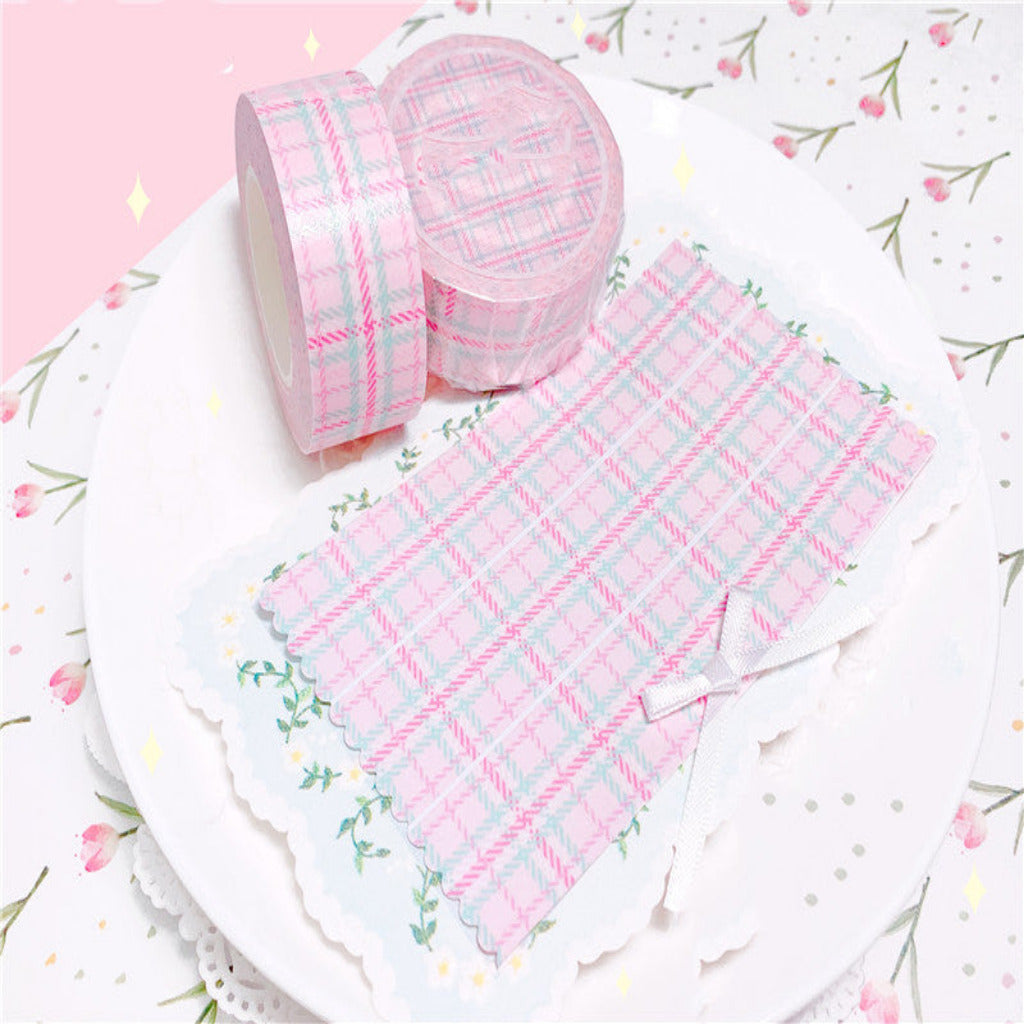 Pink and white checkered fabric with a roll on a floral patterned background