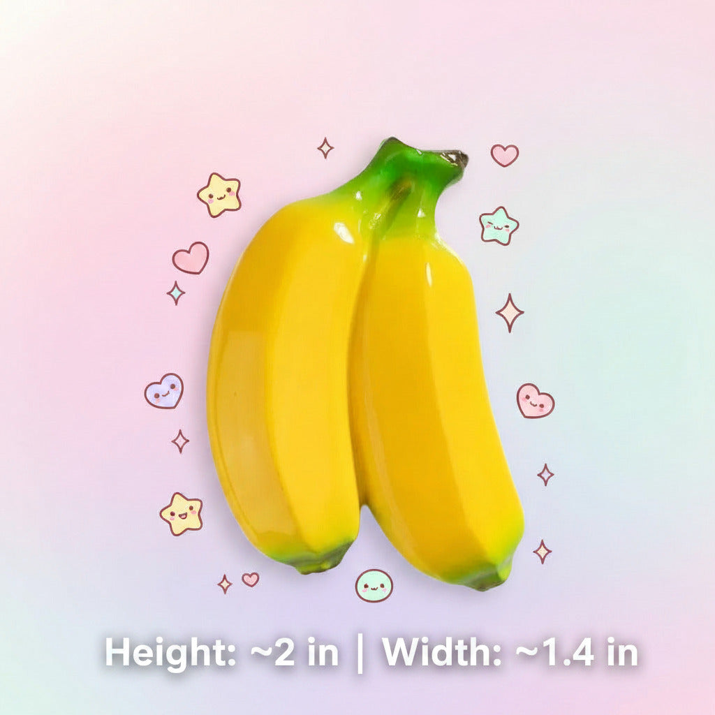 Two glossy yellow bananas with green stems and tips, shown on a white background with printed dimensions (5cm height, 3.5cm width) and text reading BX043 and Net weight about 23g.