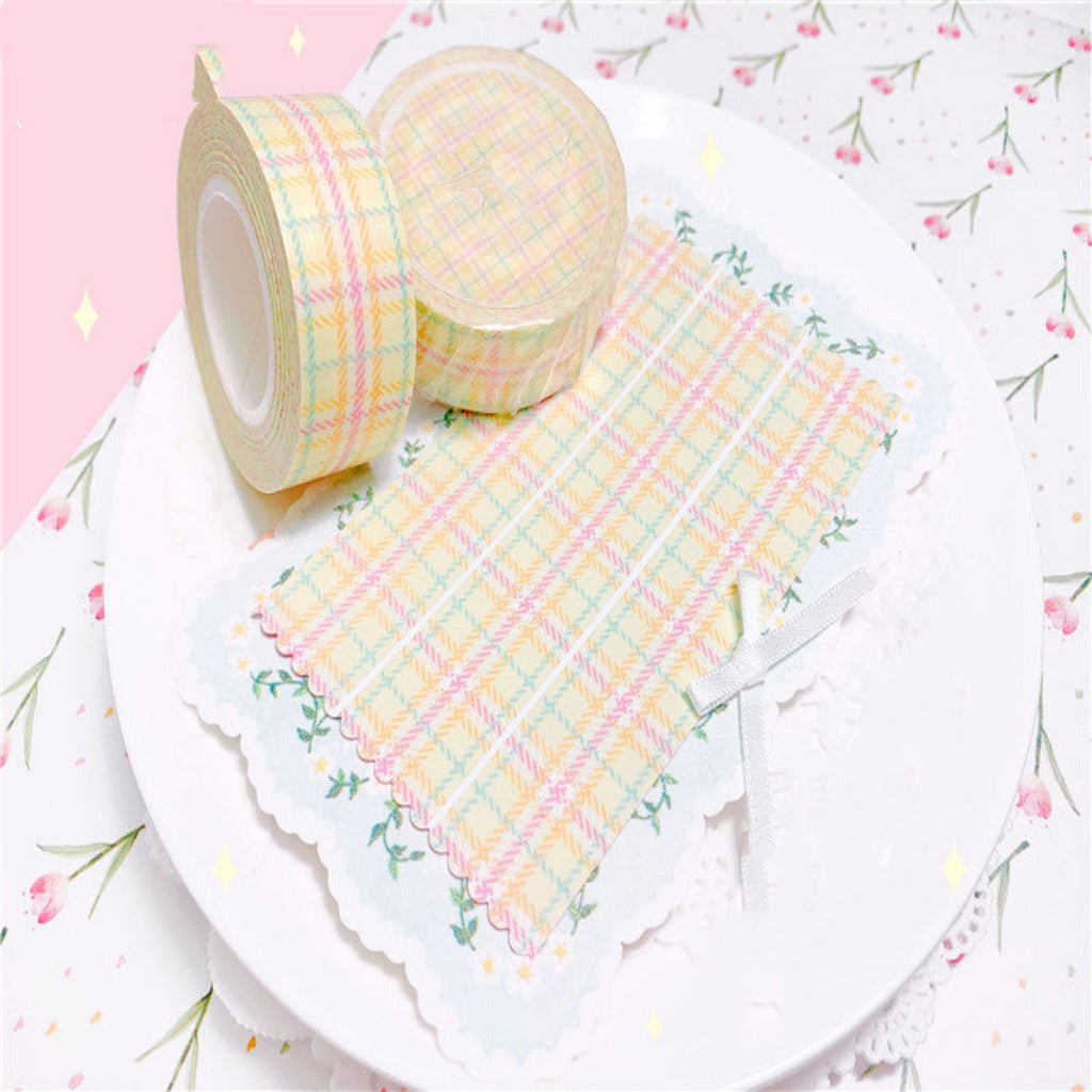 Two rolls of pastel checkered tape on a floral background