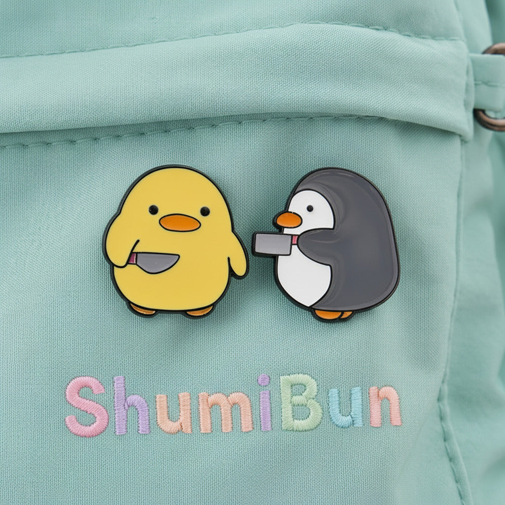 Two cartoon duck and penguin pins on a green backpack