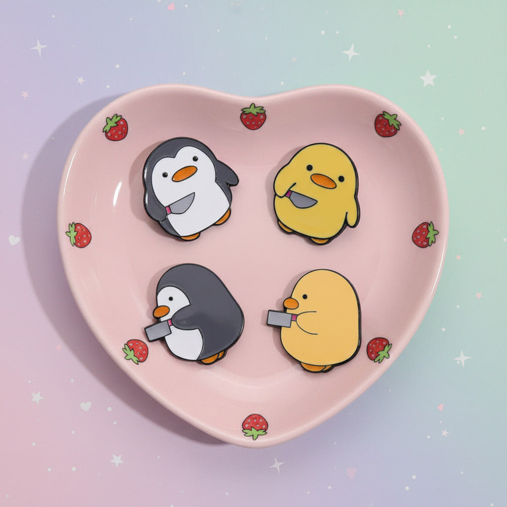 Four cartoon penguin and duck magnets on a beige plate.