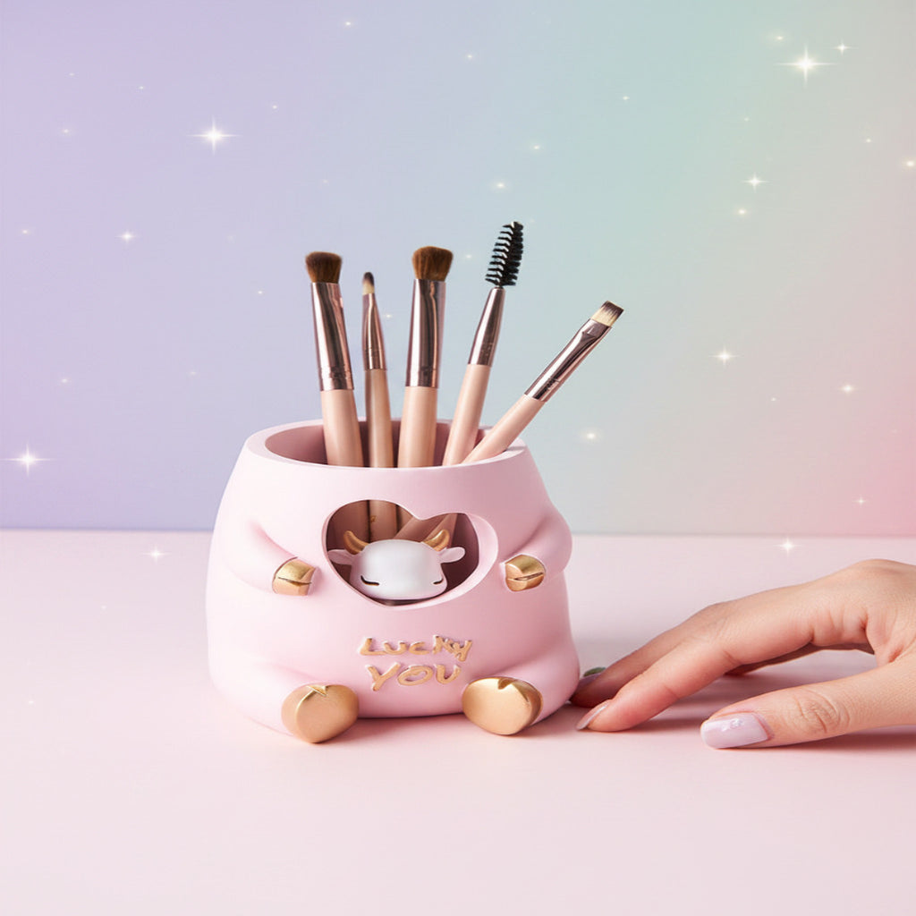 Pink makeup brush holder with various brushes on a table