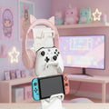 Gaming accessories including a headset, controller, and phone on a white and kawaii background