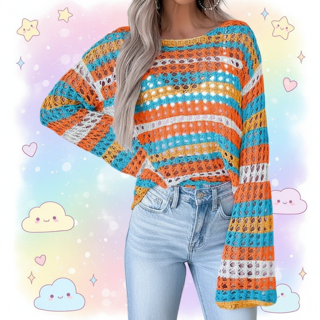 A woman wearing a colorful striped crochet knit top with wide bell sleeves and light-wash denim shorts, standing against a light gray paneled wall.